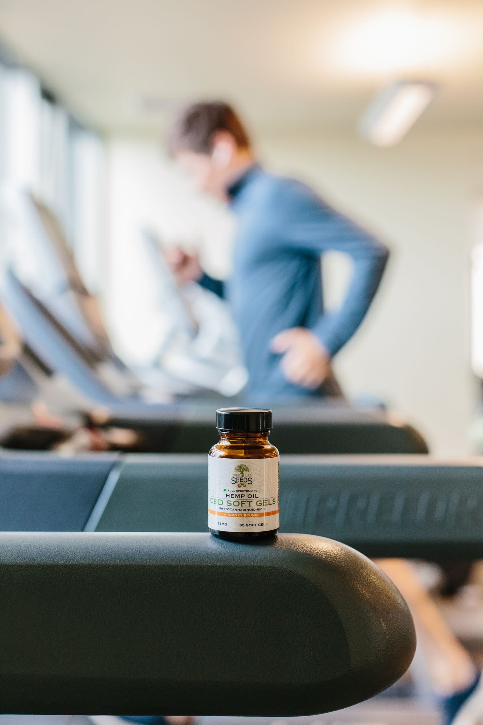 Supplement bottle on a treadmill representing sports and wellness supplements